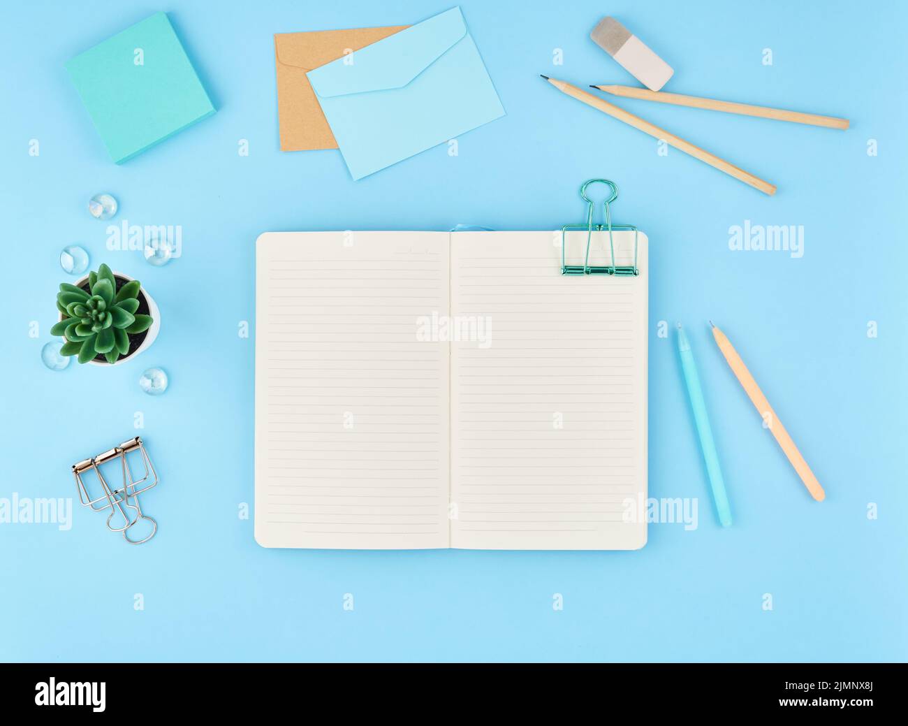 Leere Notizblockseite für Text auf blauem Büro-Desktop. Blick auf den modernen hellen Tisch mit Notizbuch Stockfoto