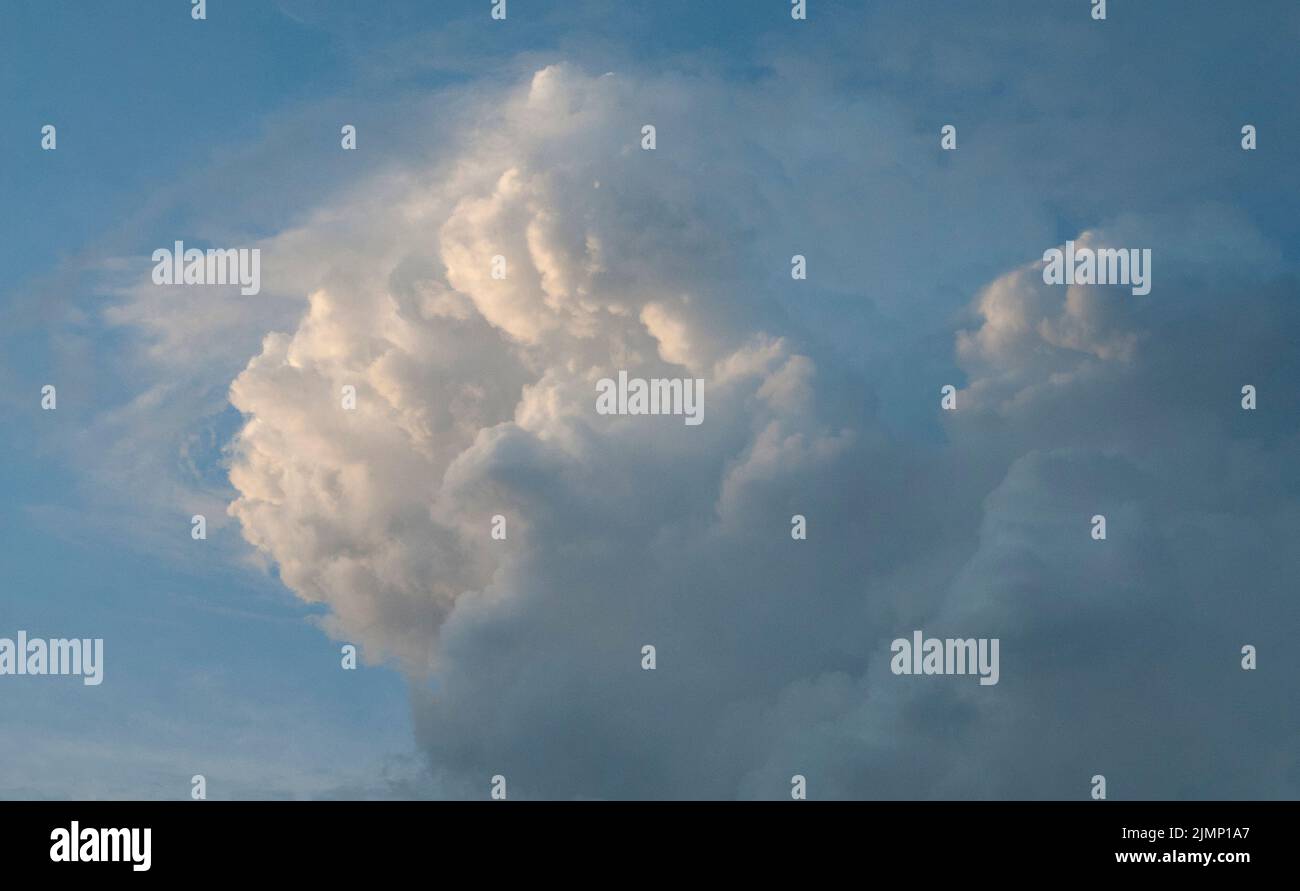 Große wogende Wolke, die sich bei Sonnenuntergang sammelt Stockfoto