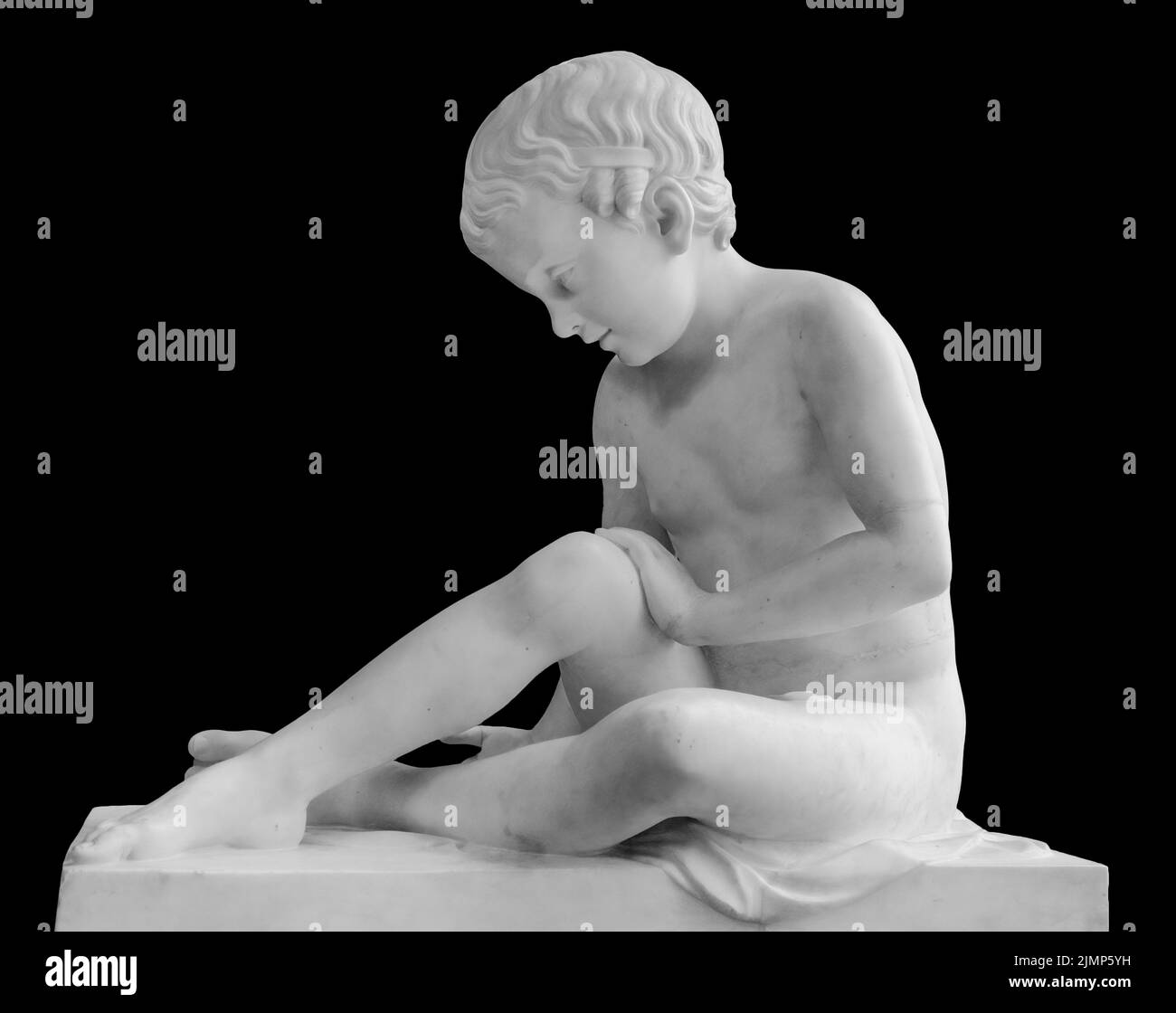Alte Marmorstatue eines sitzenden Jungen. Junge Mann Skulptur isoliert auf schwarzem Hintergrund. Antikes Steindenkmal Stockfoto