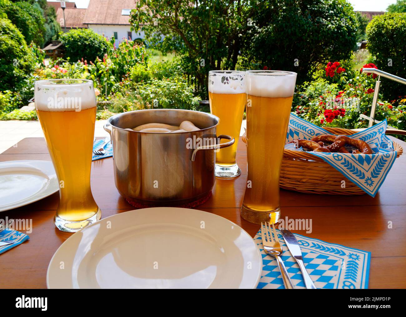 Ein traditionelles bayerisches Gericht: Weißwürste, knackige, salzige Brezeln mit süßem Senf und deutschem Bier und ein Korb mit Prezeln Stockfoto