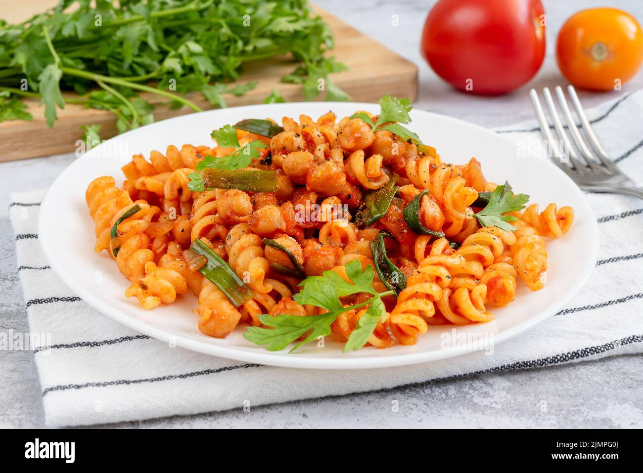 Pasta mit Tomatensauce, Kichererbsen und grünen Zwiebeln Stockfoto