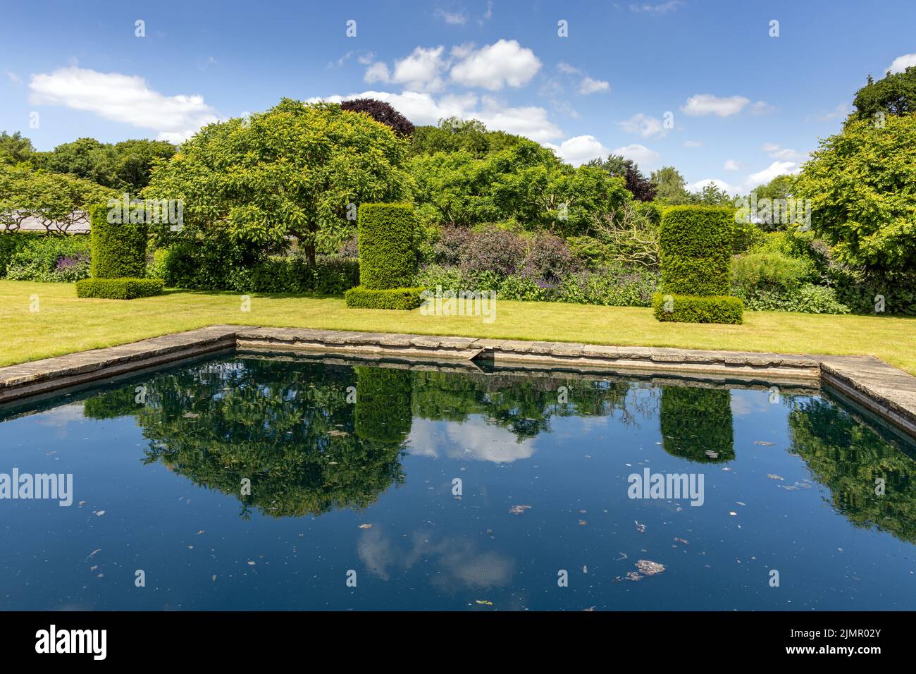 Reflektierender Teich in Scampston Hall Walled Garden, North Yorkshire, im Sommer. Ein 4 Hektar großer moderner Garten, der von Piet Oudolf entworfen wurde. Stockfoto
