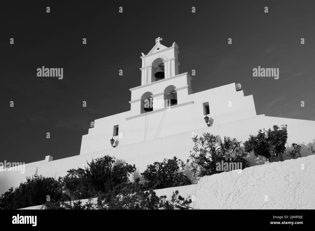 Blick auf eine wunderschöne weißgetünchte griechisch-orthodoxe Kirche auf der Insel iOS in Schwarz und Weiß Stockfoto