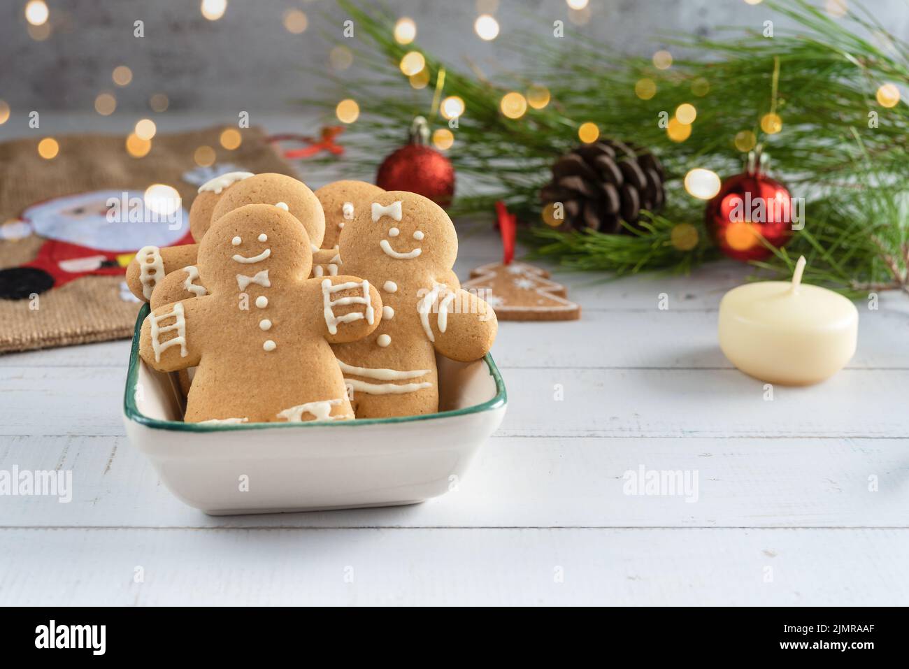 Weihnachtskarte mit Keksen Lebkuchenmann, Weihnachtsdekorationen auf einem Holzhintergrund. Stockfoto