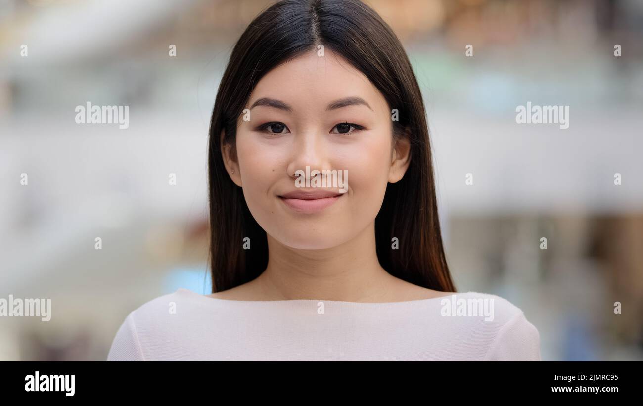 Nahaufnahme weiblich drinnen Headshot Asian glücklich lächelnd Millennial Mädchen. 20s Brünette Frau Modell Dame mit natürlichen Make-up Gesicht Kosmetologie Service Stockfoto