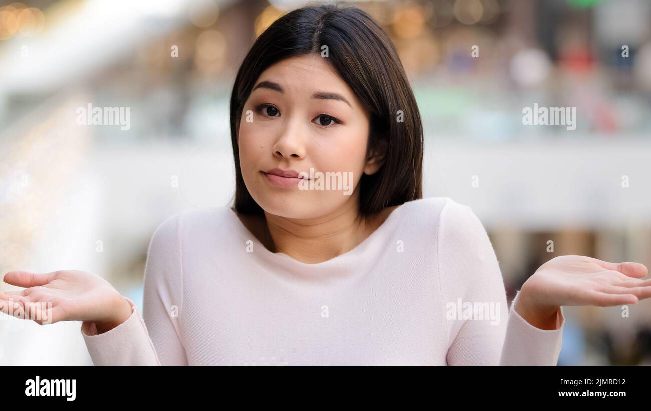 Portrait asiatisch koreanisch unsicher peinlich Mädchen weiblich Modell Student unbewusst verwirrt 20s Frau warf die Arme aus den Seiten machen Geste des Zweifels Stockfoto