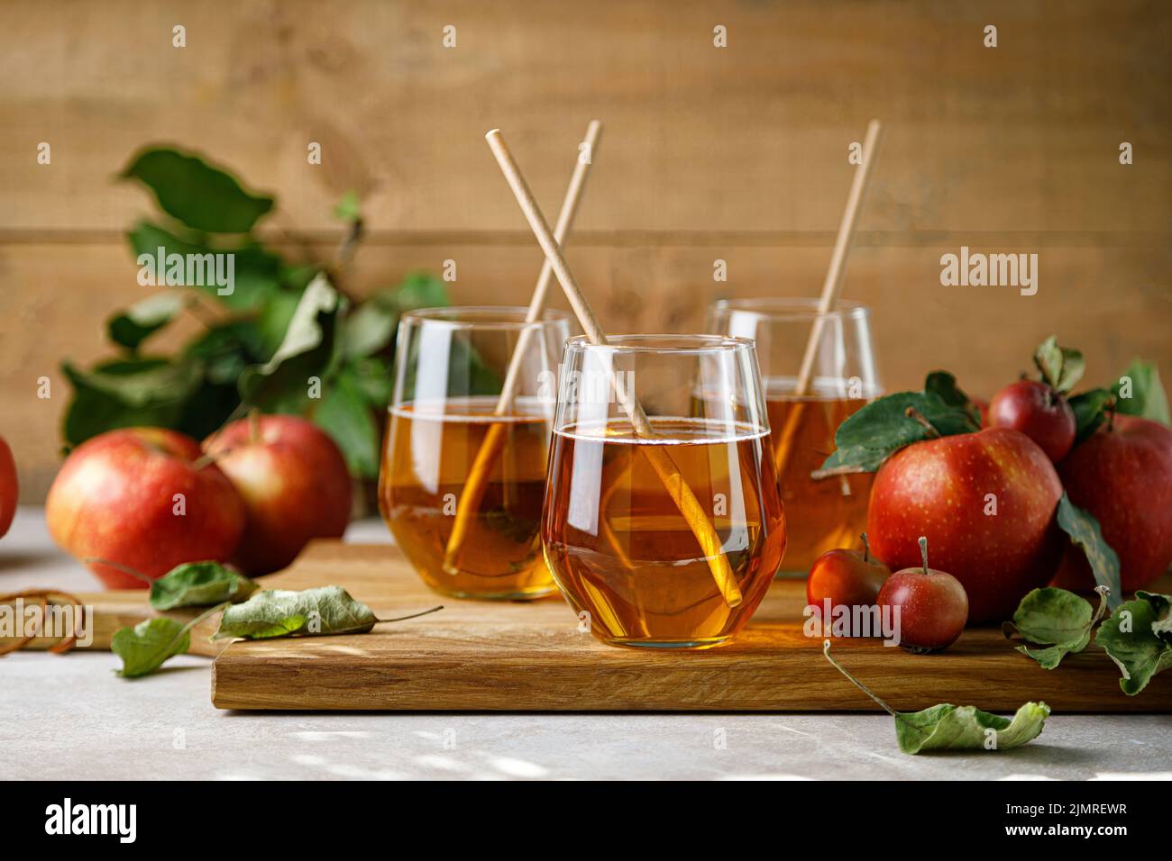 Apfelsaft im Glas und frisches Obst mit Blättern Stockfoto