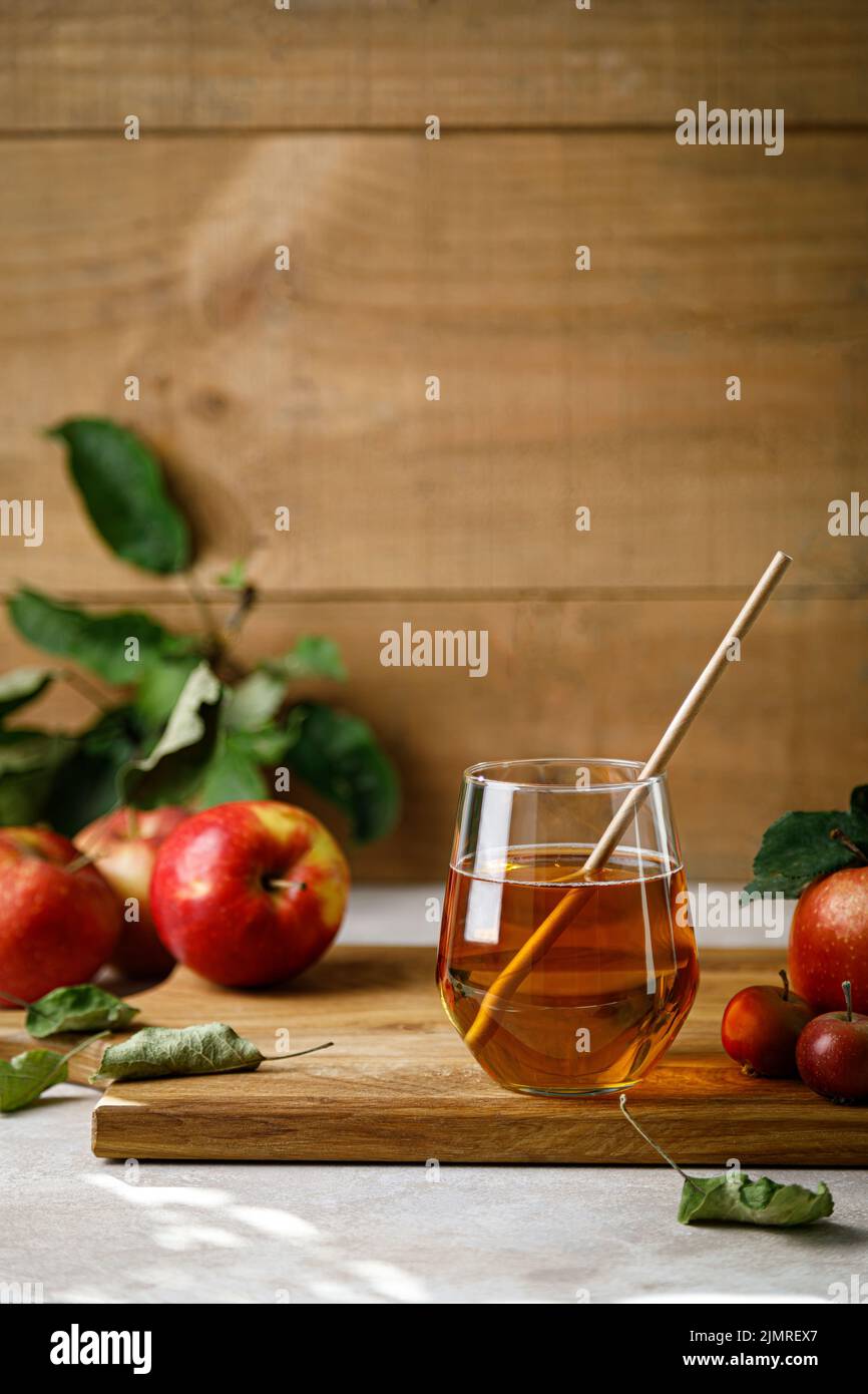 Apfelsaft im Glas und frisches Obst mit Blättern Stockfoto
