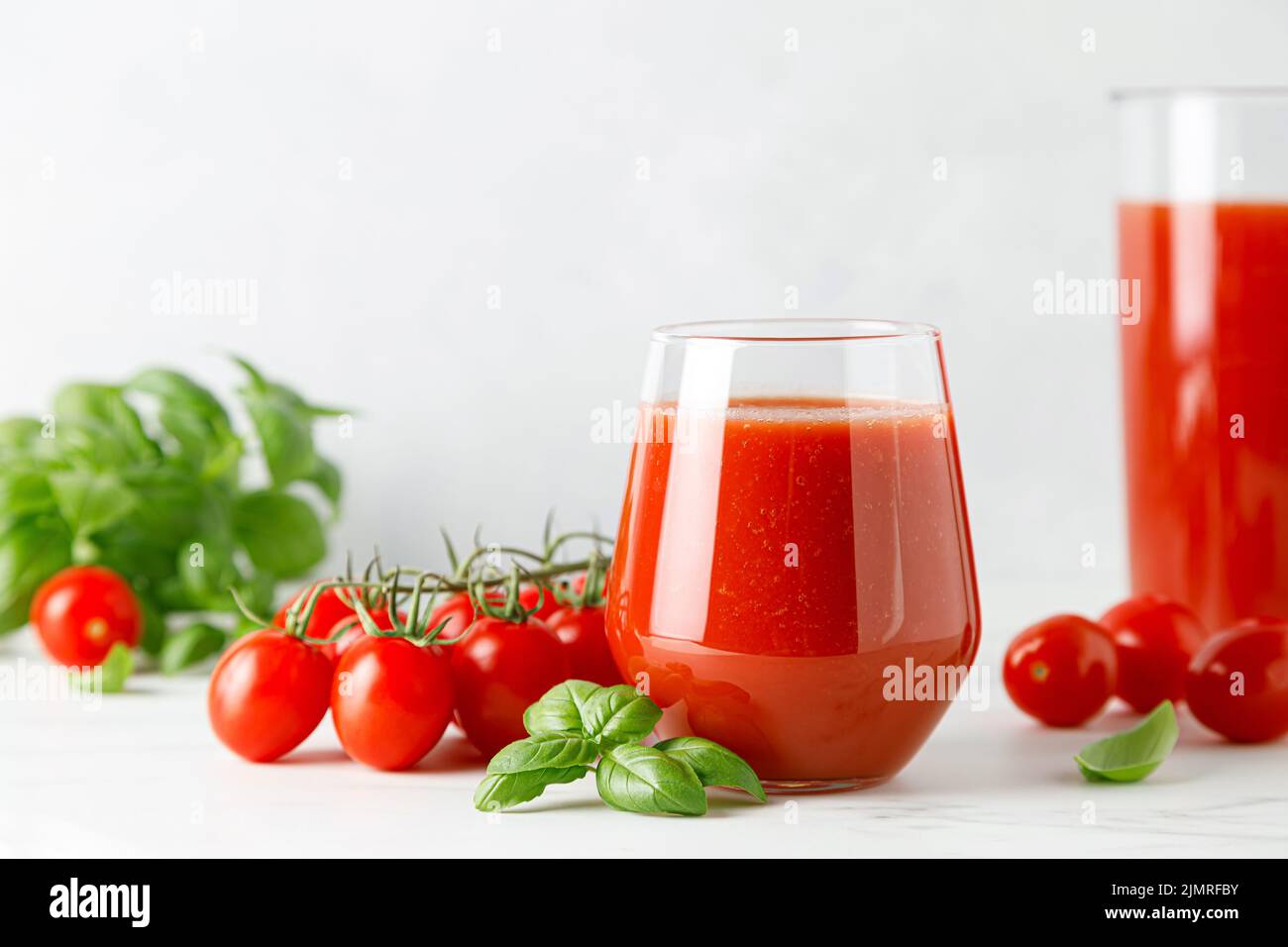 Tomatensaft im Glas und frische Tomaten Stockfoto