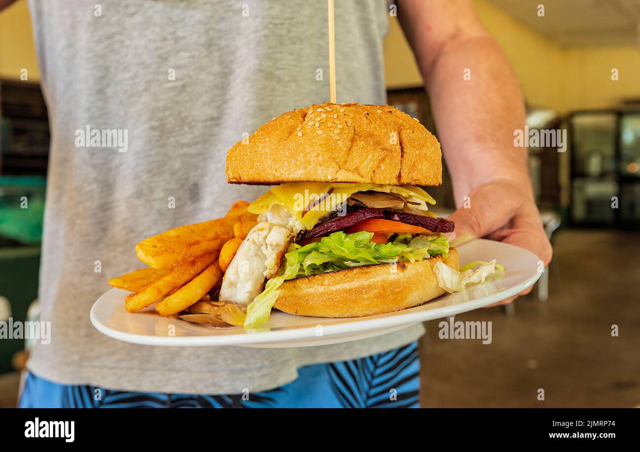 Ein sehr großer Barramundi-Burger mit Pommes Frites wird im Adelaide River Inn, Northern Territory, Australien, serviert Stockfoto