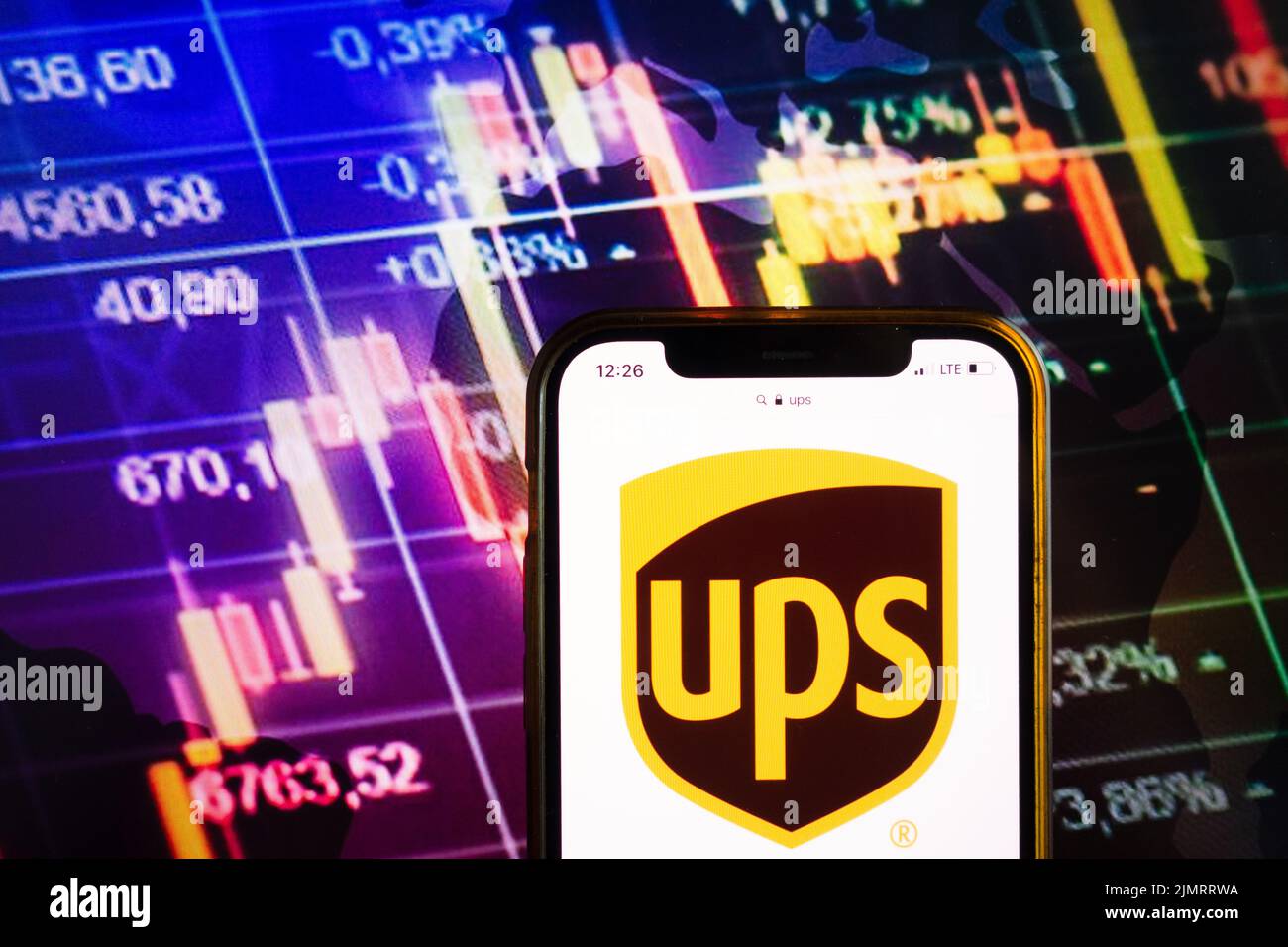 KONSKIE, POLEN - 07. August 2022: Smartphone mit Logo der Firma United Parcel Service (UPS) auf dem Hintergrund des Börsendiagramms Stockfoto