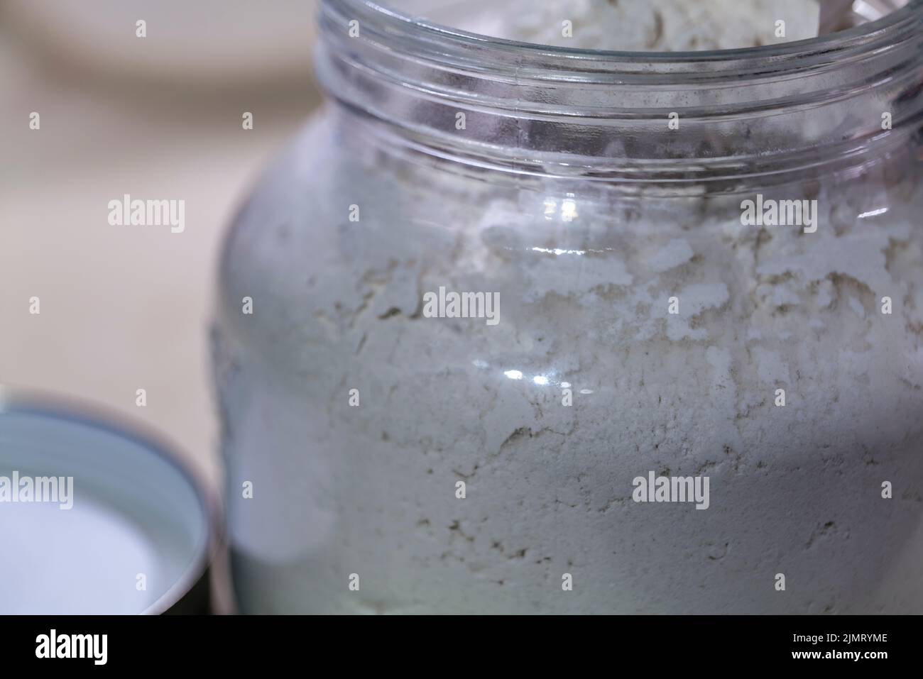 Einige gießen das Mehl zur sicheren Aufbewahrung in ein Glasgefäß. Schutz vor Insekten und Wasser. Stockfoto