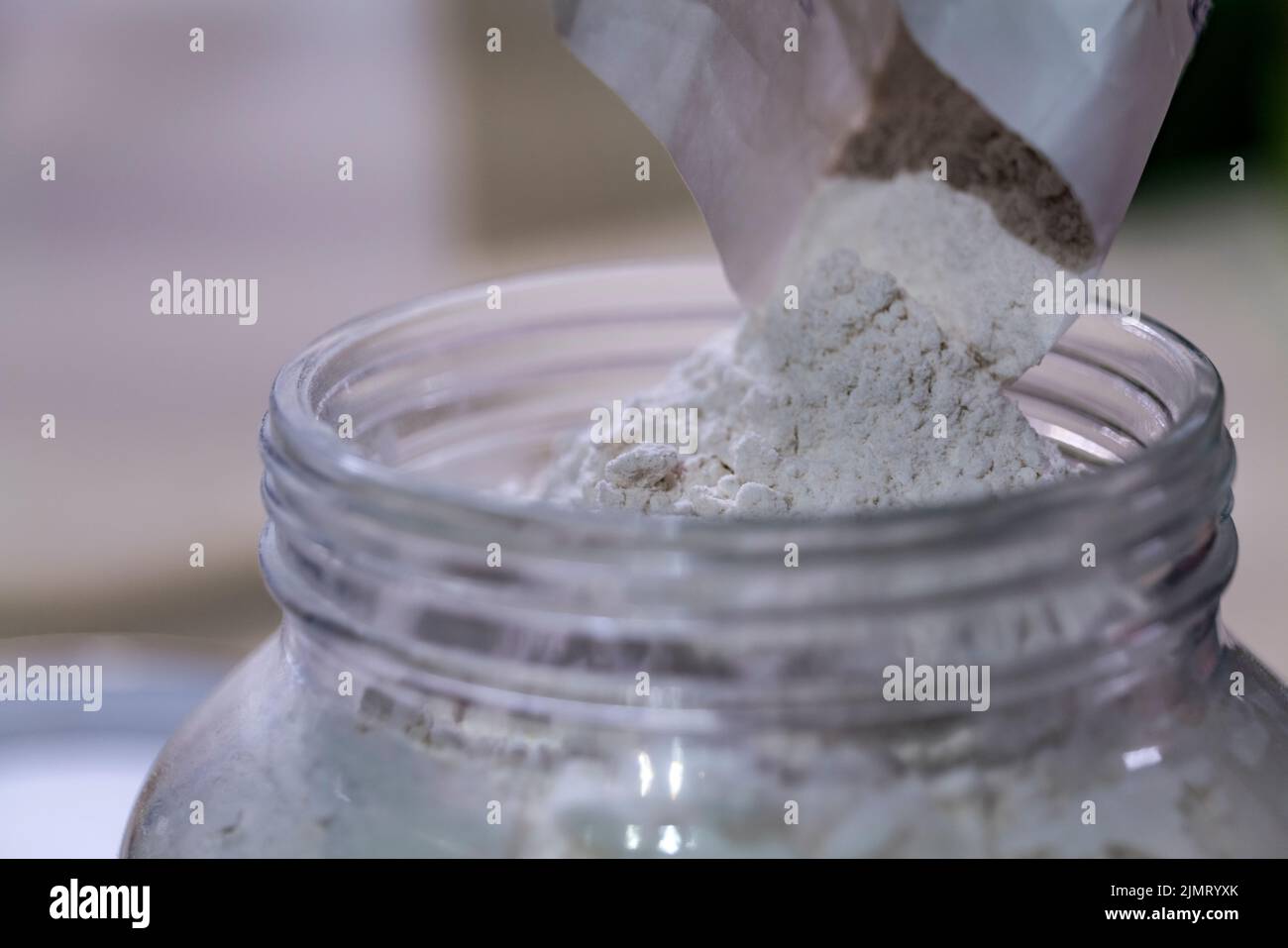 Einige gießen das Mehl zur sicheren Aufbewahrung in ein Glasgefäß. Schutz vor Insekten und Wasser. Stockfoto