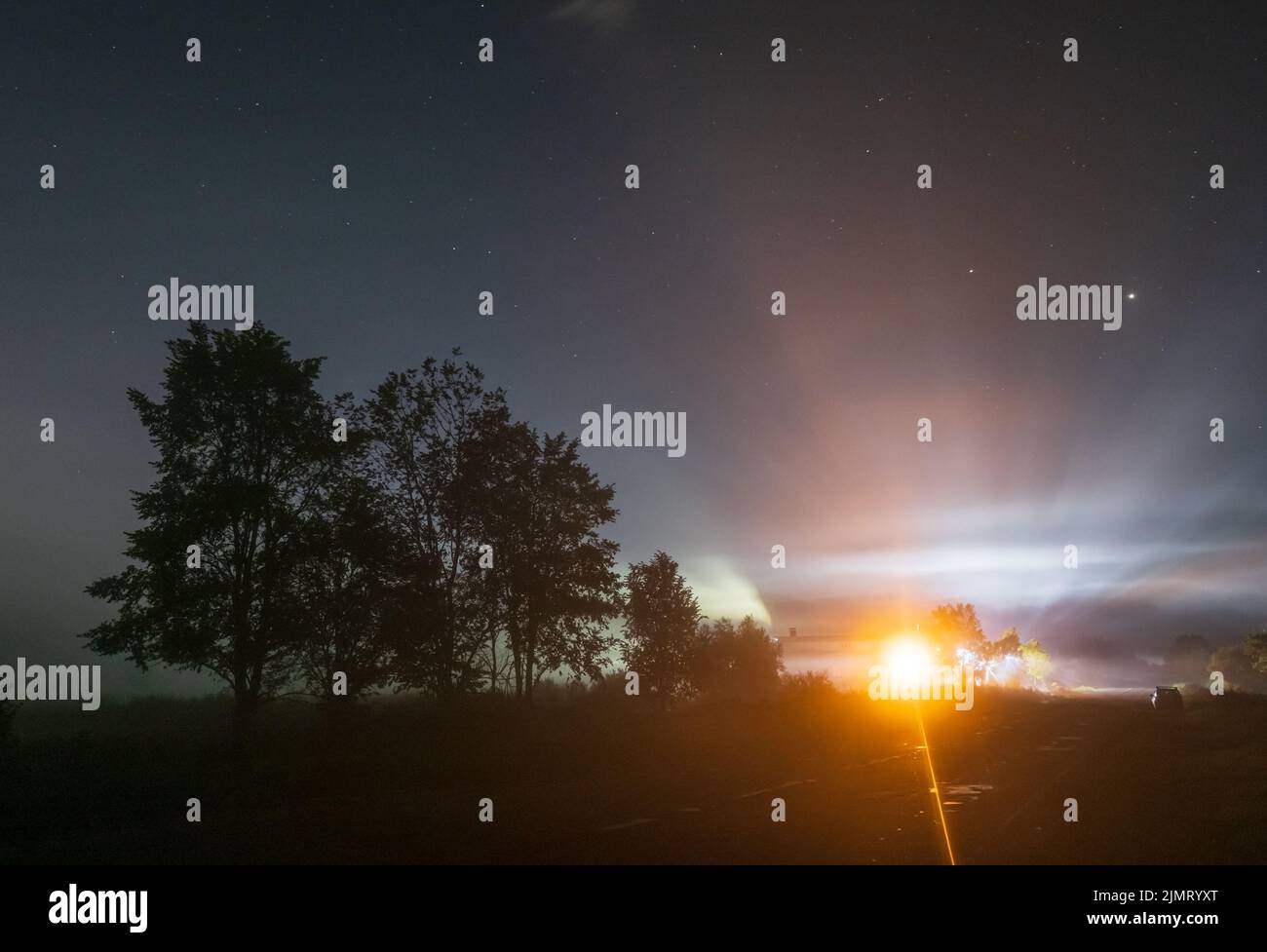Komet Neowise C2020 F3, wie er im Sommerhimmel über einer Wiese in der Nähe der Landstraße, Region Lviv, Ukraine fliegt. Stockfoto