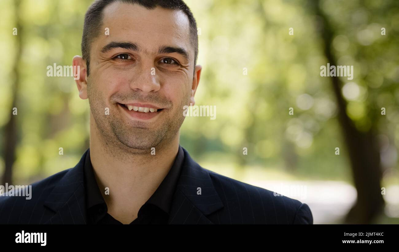 Portrait fröhlich freundlich kaukasischen arabischen Geschäftsmann erfolgreichen Verkäufer clever Freiberufler trägt formelle Anzug steht im Stadtpark schaut zur Seite Stockfoto