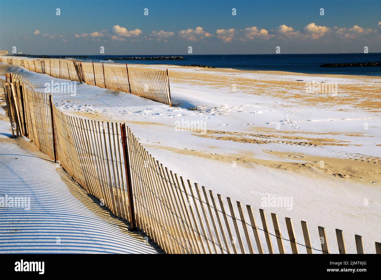 Schnee bedeckt den Sand am Strand von Avon am Meer, am Atlantischen Ozean an der Küste von Jersey, was eine leere Off-Season-Szene schafft Stockfoto