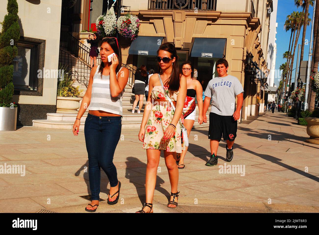 Junge Leute schlendern den Rodeo Drive in Beverly Hills entlang, in der Nähe von Los Angeles, Einkaufsmöglichkeiten und den Luxusgeschäften und Modeläden der Spitzklasse Stockfoto