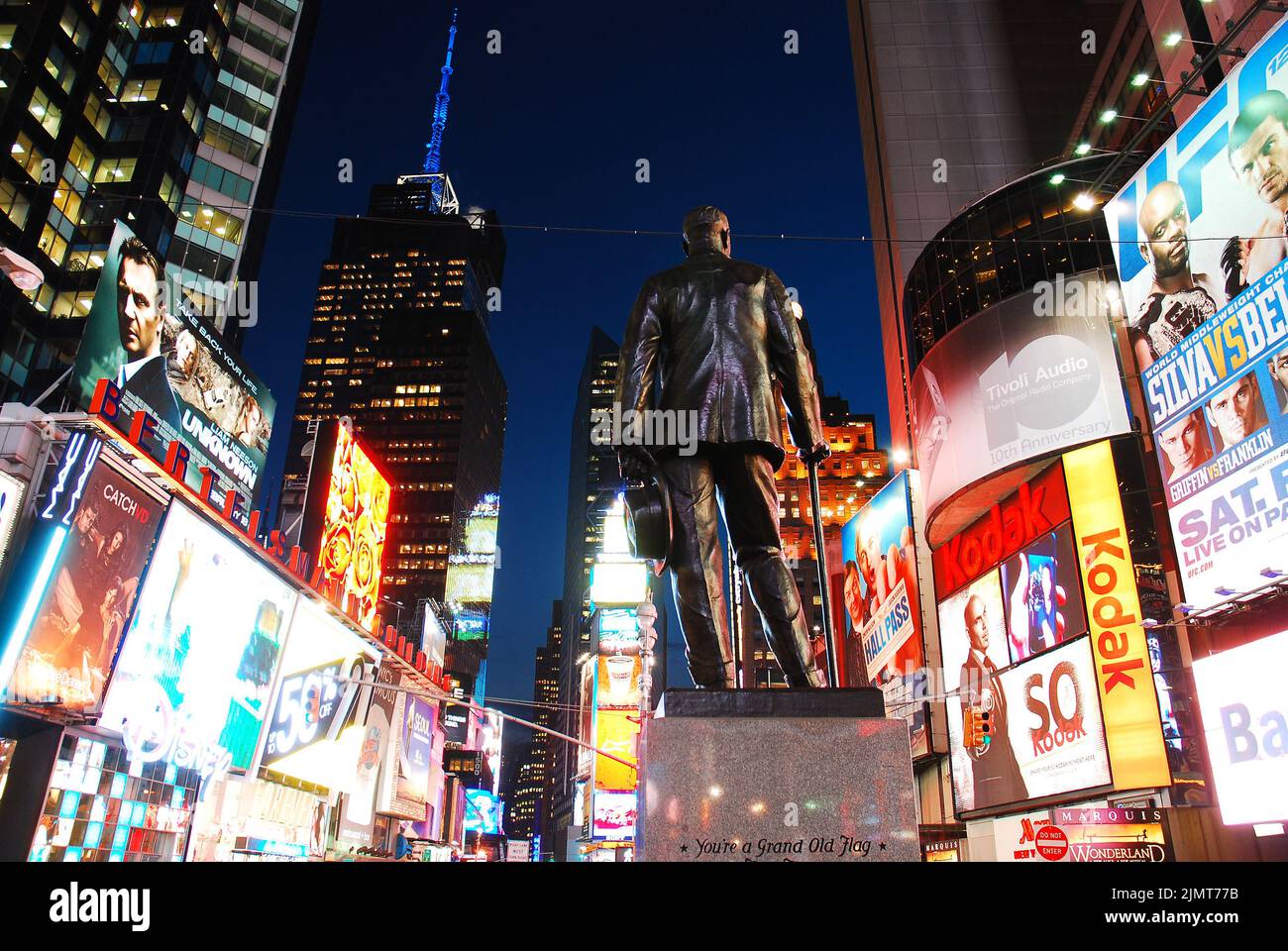 Eine Skulptur von George M Cohan, der Give my regards to Broadway schrieb, steht im Herzen des Times Square, New York City, umgeben von hellen Anzeigen Stockfoto