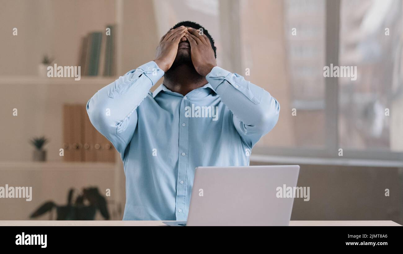 Frustriert schockiert afrikanischen Geschäftsmann amerikanischen erwachsenen Mann Student Arbeit am Computer Fehler Fehler fühlt sich Stress aufgeregt mit schlechten Nachrichten Scheitern e Stockfoto