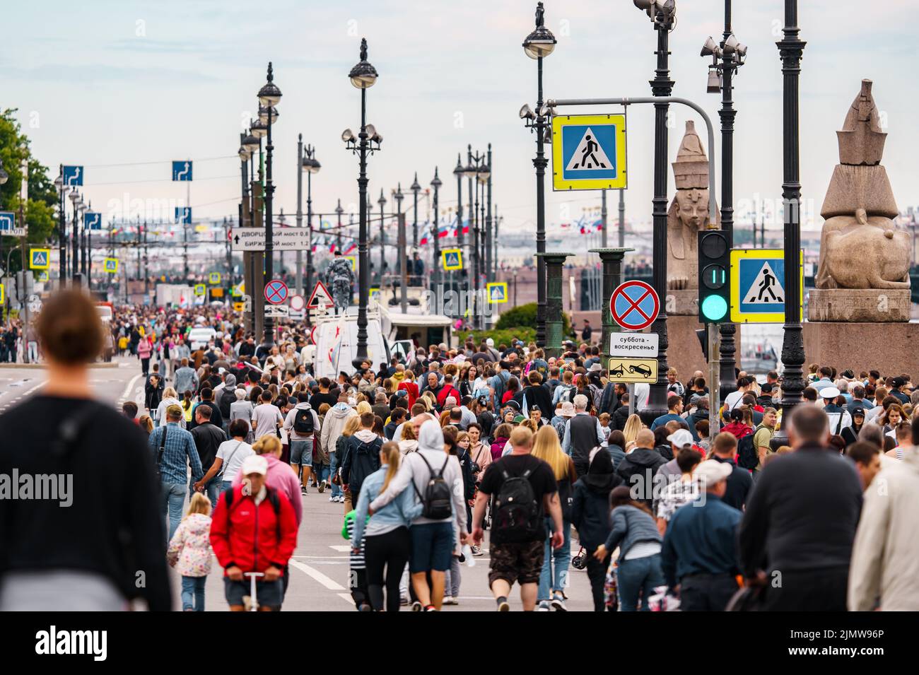 Russland, St. Petersburg, 31. Juli 2022: Viele Menschen während der Feier des Tages der Marine auf der Universität Böschung, Laternenpfosten Stockfoto