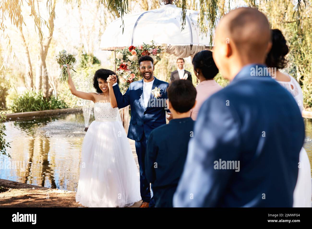 Die Kraft der Liebe hat uns alle heute hierher gebracht. Ein glückliches, frisch verheiratetes junges Paar, das am Hochzeitstag vor den Gästen den Gang entlang geht. Stockfoto Die Kraft der Liebe hat uns alle heute hierher gebracht. Ein glückliches, frisch verheiratetes junges Paar, das am Hochzeitstag vor den Gästen den Gang entlang geht. Stockfoto