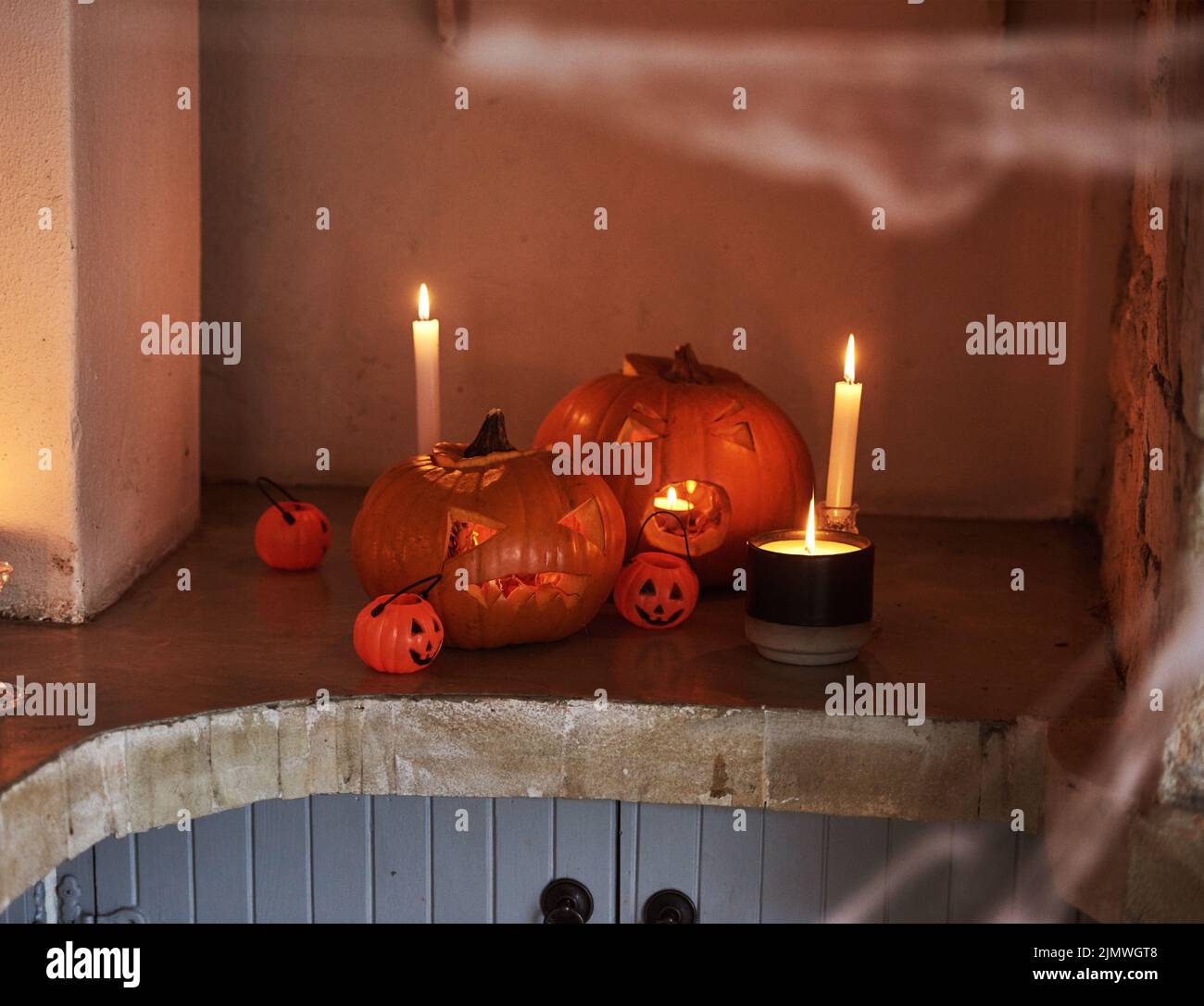 Dies ist ein beängstigender Anblick. Stillleben von geschnitzten Kürbissen und brennenden Kerzen zusammen zur Feier von halloween platziert. Stockfoto
