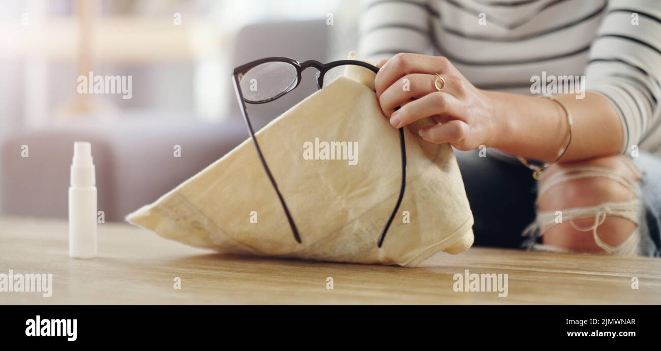 Verschreibungspflichtige Gläser sind sehr leicht zu reinigen. Eine unkenntliche Frau putzt ihre Lesebrille zu Hause. Stockfoto