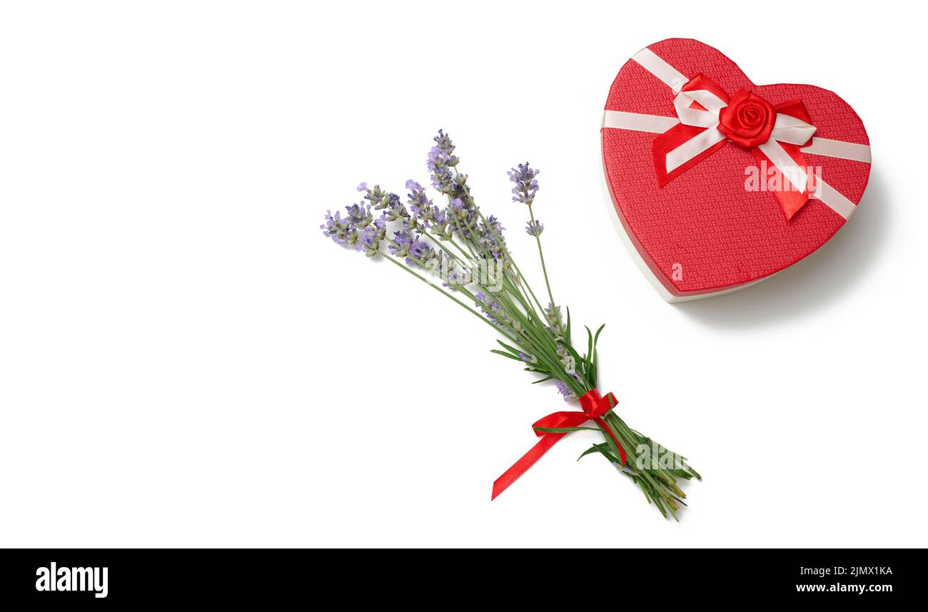 Lavendel-Bouquet und herzförmige Pappe rote Geschenkbox auf weißem Hintergrund, Draufsicht Stockfoto
