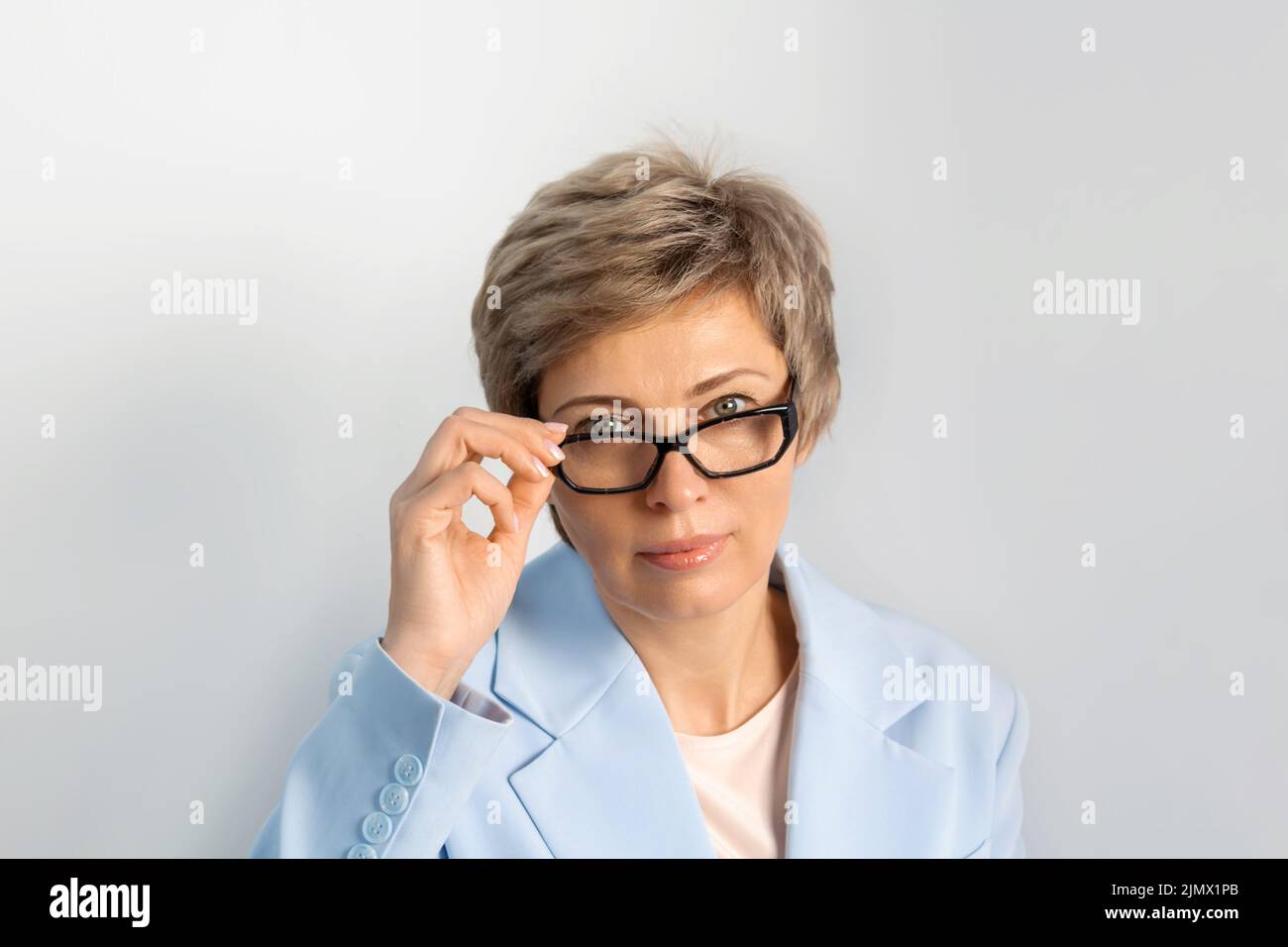 Porträt einer Geschäftsfrau in blauem Anzug, Brille. Stockfoto