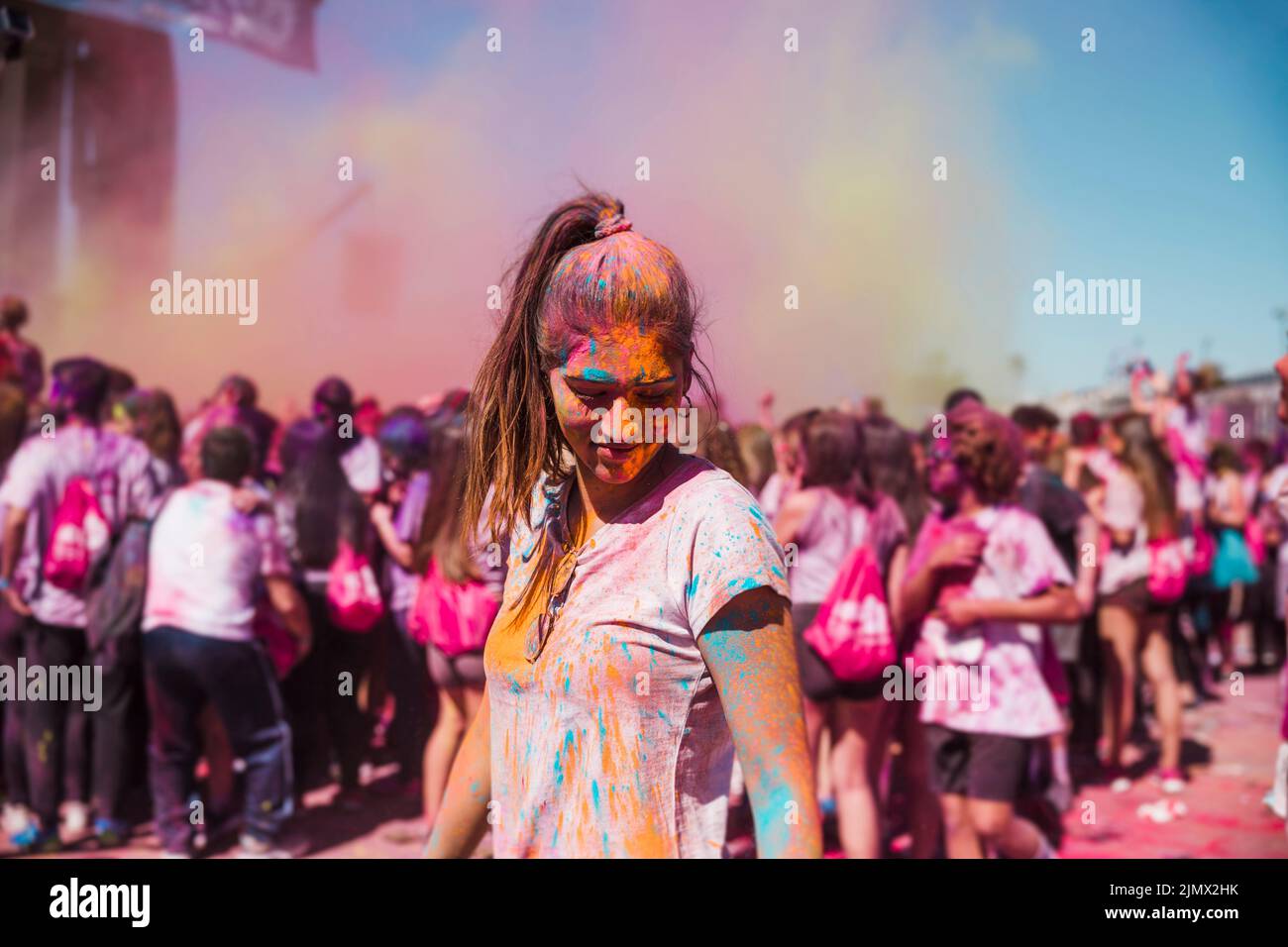 Junge Frau genießt mit holi Farbe Menge Stockfoto