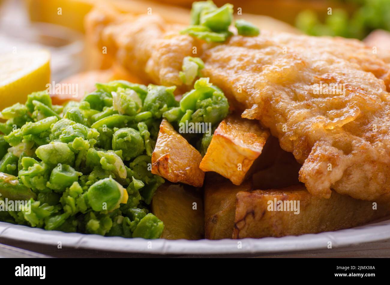 Traditionelle britische Street Food Fish und Chips mit Erbsenpüree auf Papier Platte Stockfoto