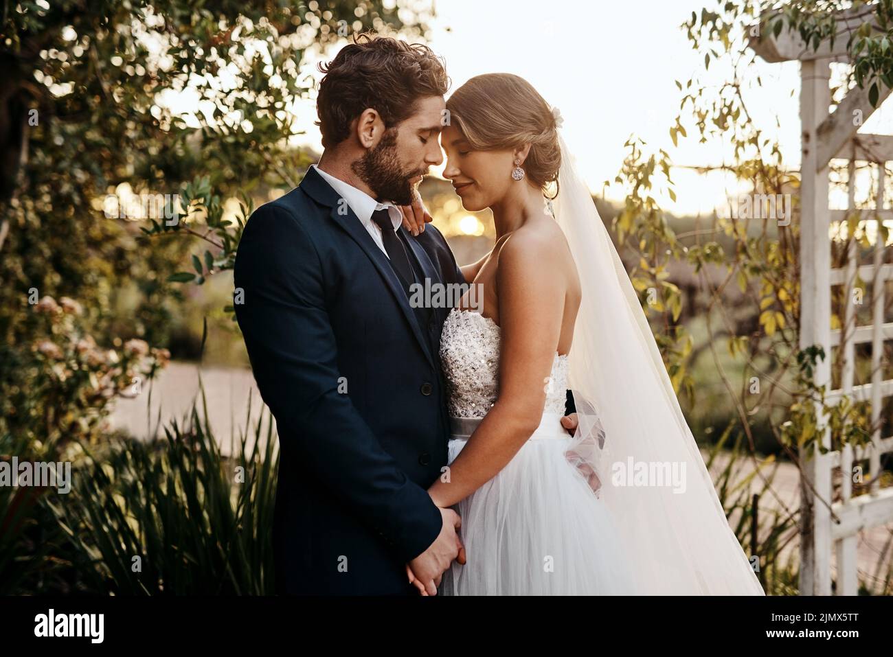 Wir glauben, dass unsere Liebe alles aushalten kann. Ein glückliches junges Paar, das an ihrem Hochzeitstag zusammensteht. Stockfoto
