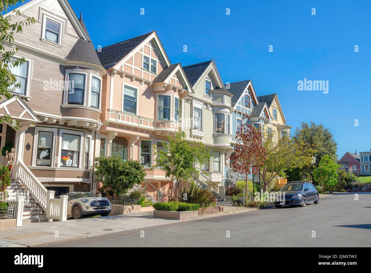 Komplexe Häuser mit Kellergaragen und Treppen an der Vorderseite in San Francisco, Kalifornien. Auf der linken Seite befindet sich ein Haus mit Holloween-Ornamenten und p Stockfoto