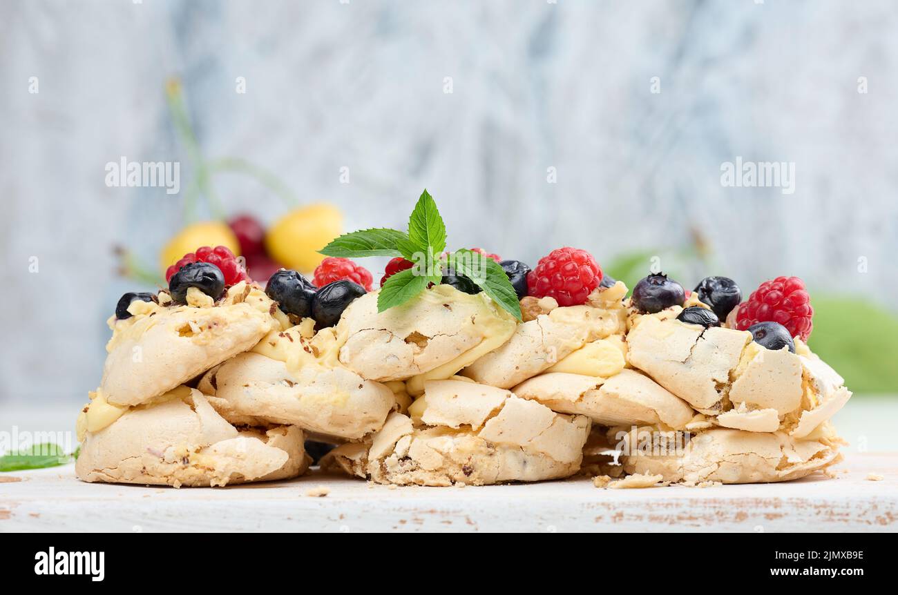 Ein gebackener Kuchen aus geschlagenem Hühnerprotein und Rahm, verziert mit frischen Beeren. Dessert Pavlova Stockfoto