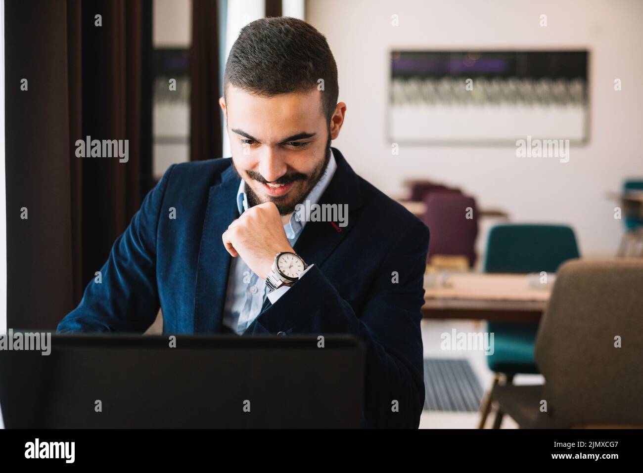 Fröhlicher, eleganter Mann mit Laptop Stockfoto