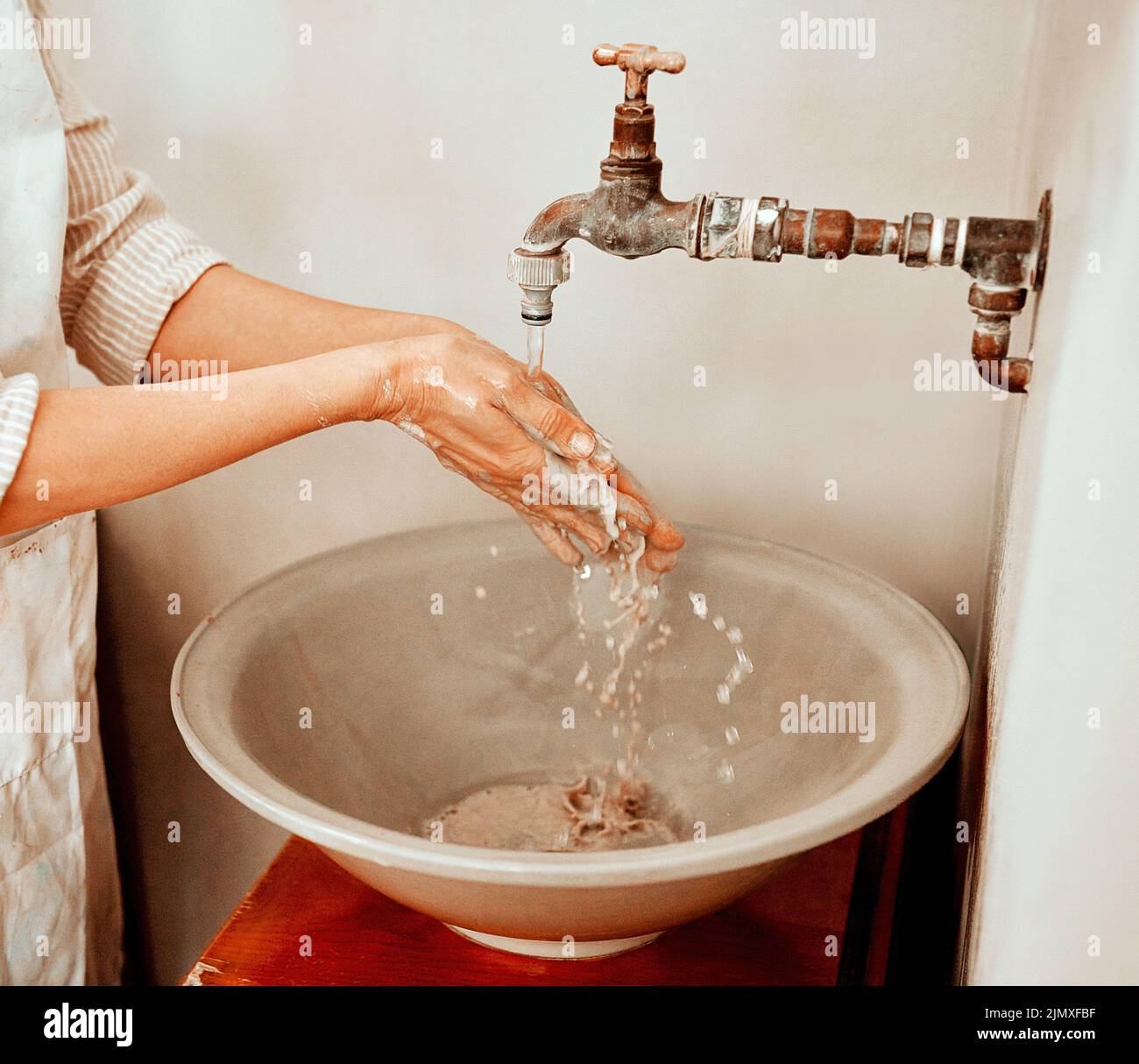 Sie können nicht Spaß haben, ohne schmutzig zu werden. Eine unkenntliche Frau, die ihre Hände wäscht. Stockfoto