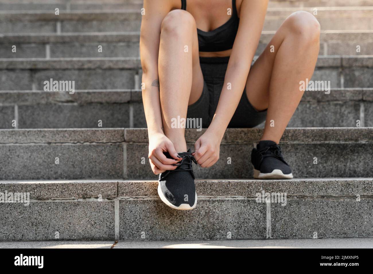 Vorderansicht Frau schnürt ihre Schnürsenkel vor dem Training Stockfoto