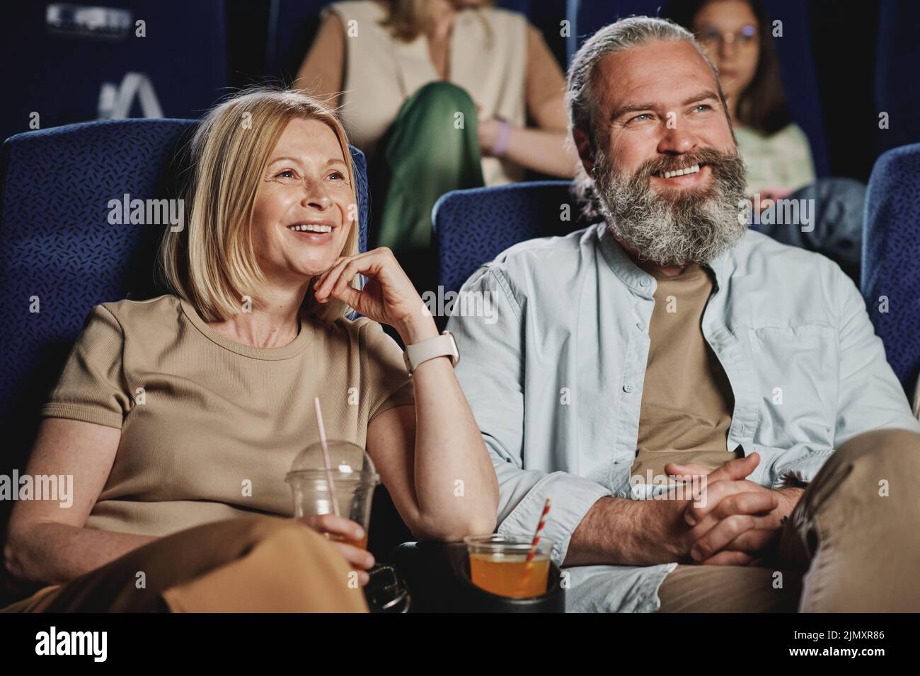 Horizontales mittleres Porträt eines erwachsenen kaukasischen Mannes und einer Frau, die am Wochenende einen Film im Kino sehen Stockfoto