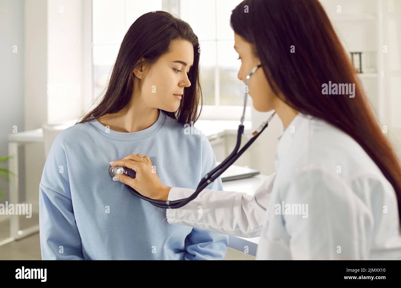 Die Frau wird während einer medizinischen Untersuchung in der Arztpraxis auf Herz und Lunge untersucht Stockfoto