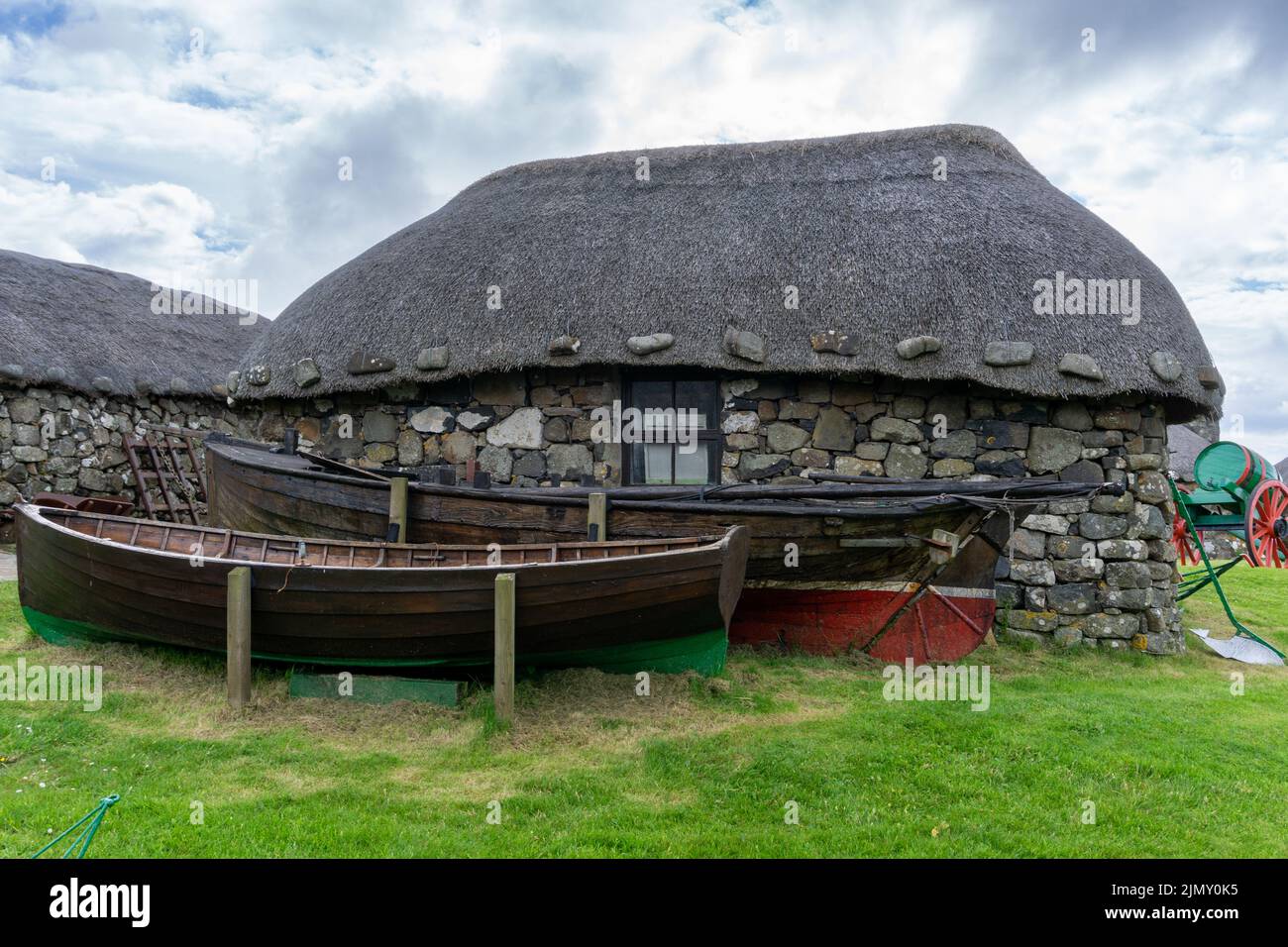 Das Skye Museum of Island Life in Kilmuir an der Küste der Isle of Skye mit strohgedeckten Hütten und Booten Stockfoto