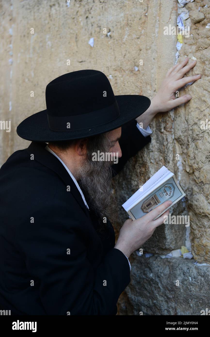 Ein jüdischer Mann, der am Tisha B'AV Tag vor der Klagemauer in der Altstadt von Jerusalem betet. Stockfoto