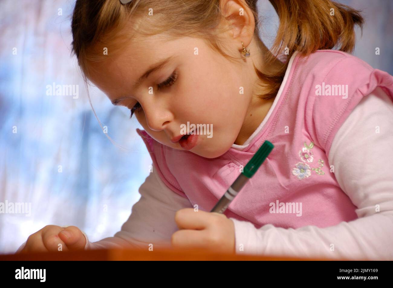 Kleines Mädchen schreibt auf einem Notizbuch, zurück zur Schule Konzept Stockfoto