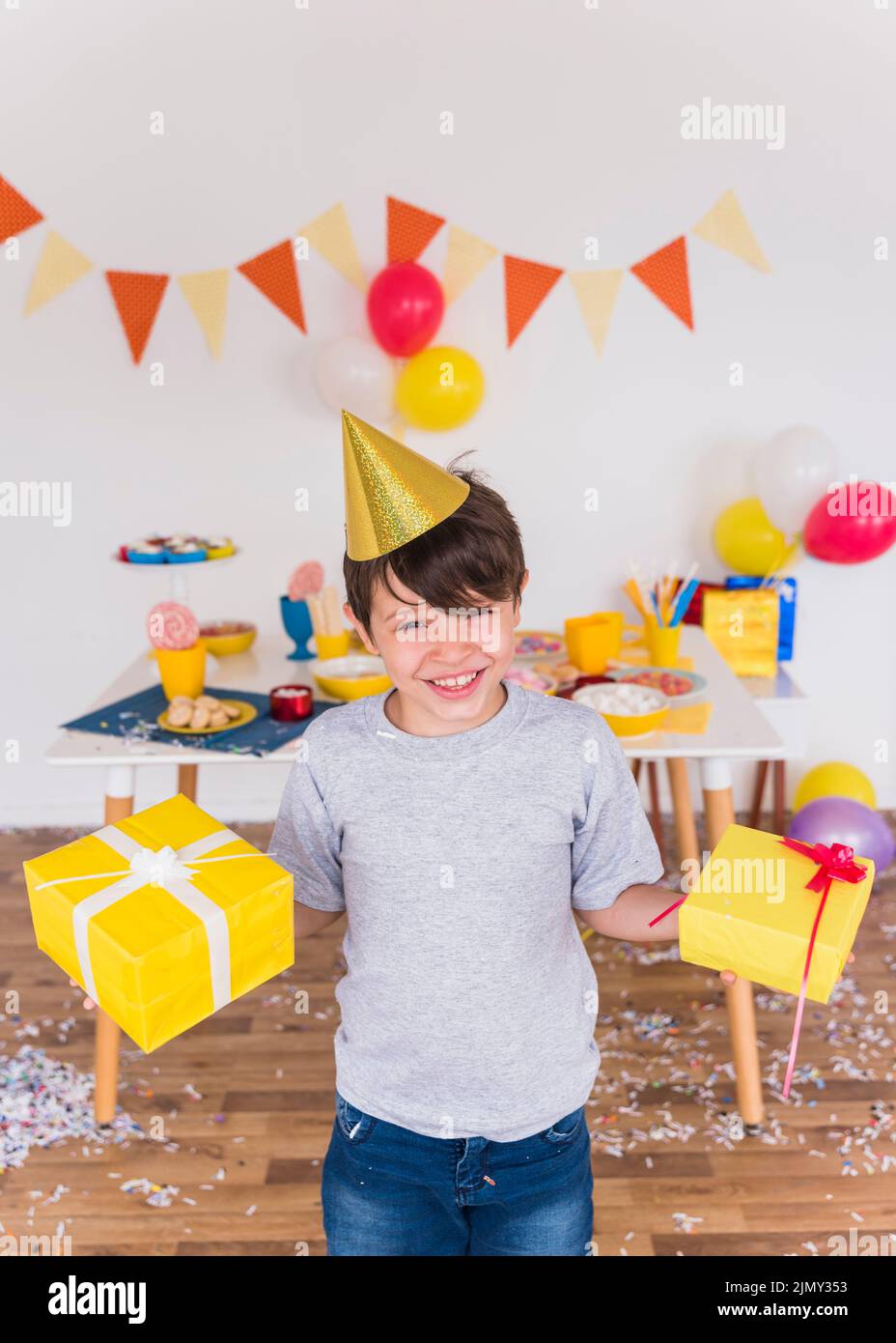 Portrait lächelnder Junge hält Geburtstagsgeschenk nach Hause Stockfoto