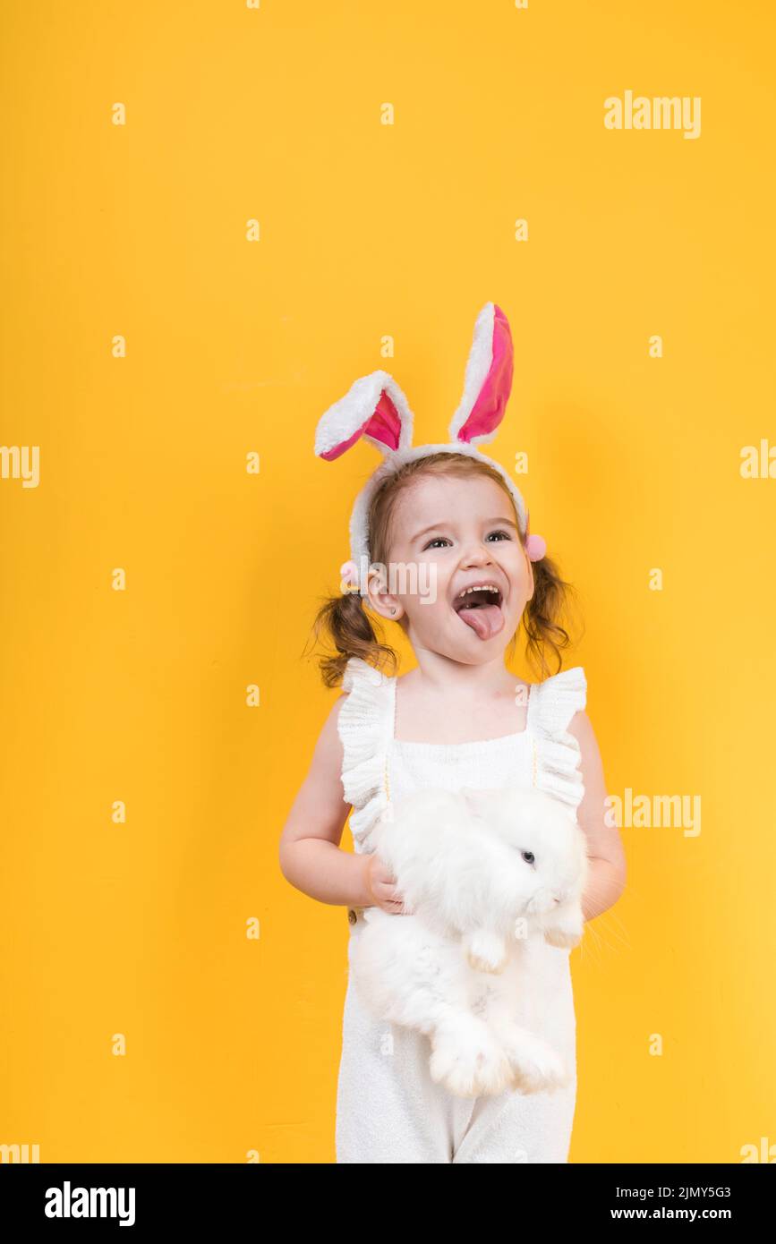 Kleines Mädchen Hase Ohren mit Kaninchen zeigen Zunge Stockfoto