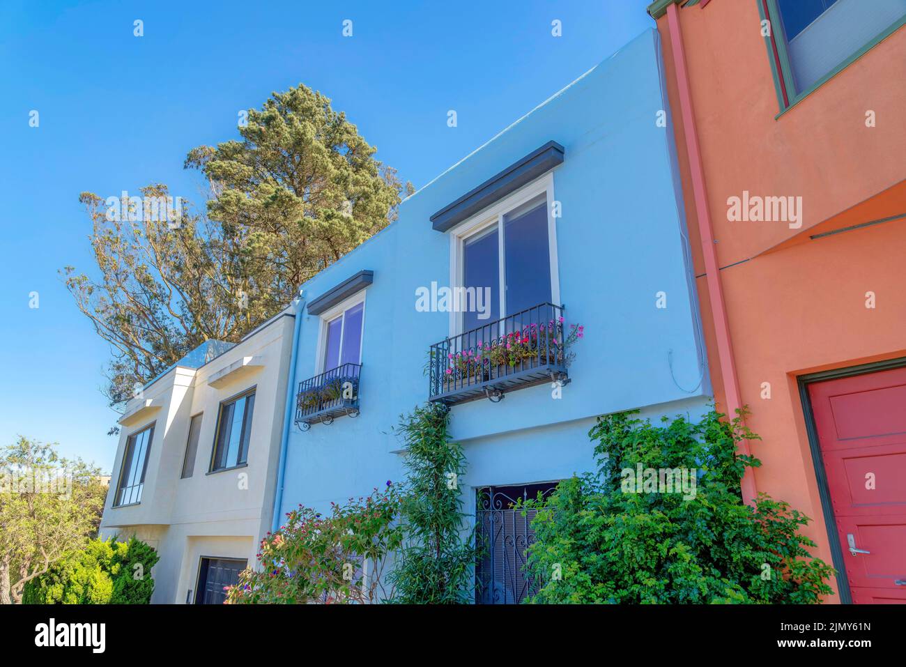 Kleine Häuser in der Nachbarschaft in San Francisco, Kalifornien mit bemalten Wänden. Es gibt ein Haus auf der linken Seite mit beigefarbener Wand neben dem Haus in der Stockfoto