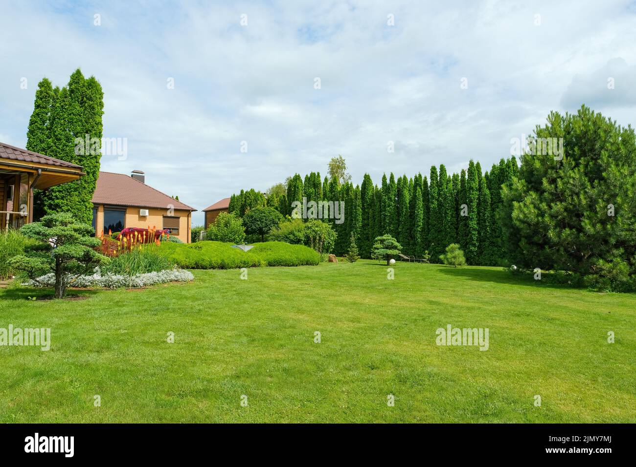 Landhaus auf Rasen in der Nähe von üppigen grünen Wäldern Stockfoto