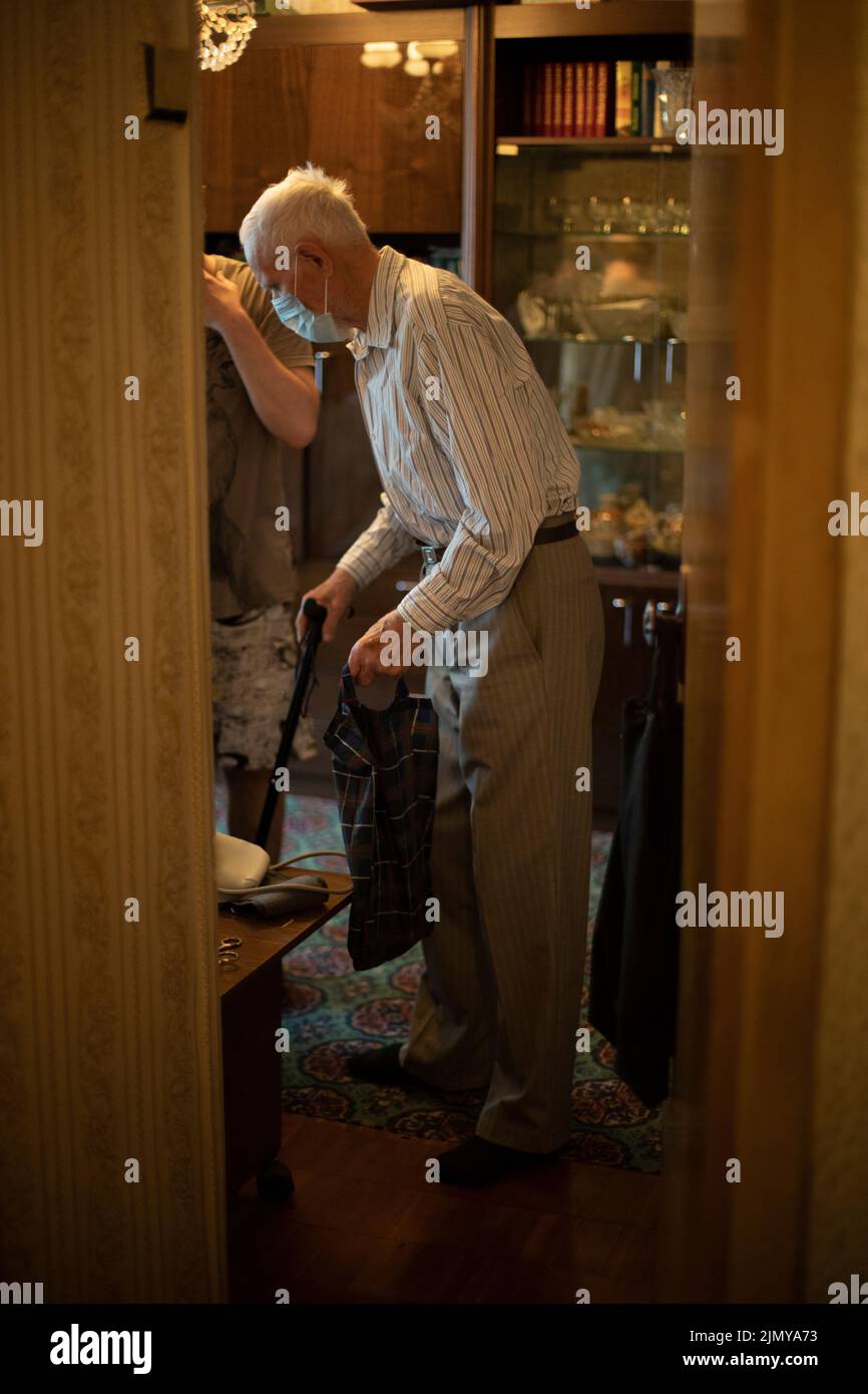 Alter Mann in der Wohnung. Opa geht nach draußen. Rentner in Russland. Alter Mann in medizinischer Maske. Stockfoto