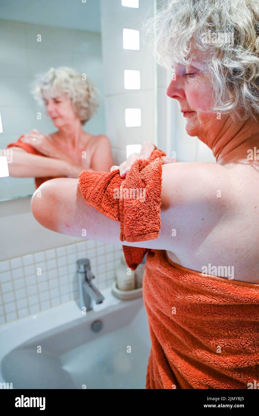 Frau, die mit einem Flanell und Seife am Waschbecken im Badezimmer wascht, um Wasser zu sparen, da in einigen Gebieten Großbritanniens Wasserknappheit herrscht Stockfoto