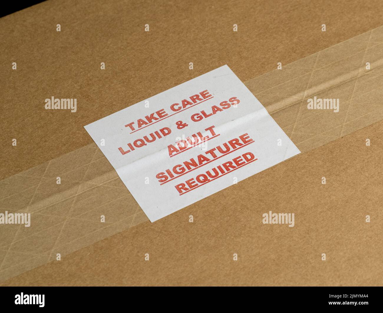 Take Care Flüssigkeit und Glas Erwachsene Unterschrift erforderlich: Etikett auf einem versiegelten braunen Karton. Stockfoto