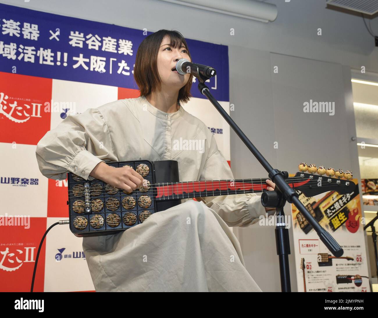 Die Sängerin SAE Banjoya spielt am 8. August 2022 in Osaka die von Yamano Music Co. Und Iwatani Corp. Gemeinsam entwickelte "Takoyaki"-Gitarre (Oktopus-Kugeln). (Kyodo)==Kyodo Foto via Credit: Newscom/Alamy Live News Stockfoto